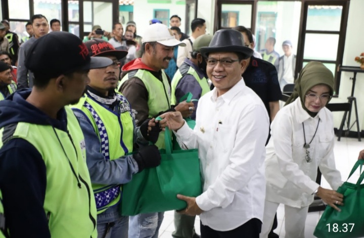 Bupati Bandung Dr HM Dadang Supriatna saat memberikan bantuan paket sembako kepada para tukang ojeg.(Foto: Diskominfo Kab Bandung)