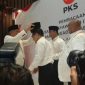 Presiden PKS Ahmad Syaikhu memakaikan peci hitam kepada Anies dan Cak Imin, usai me gumumkan dukungannya. (Foto/Istimewa)