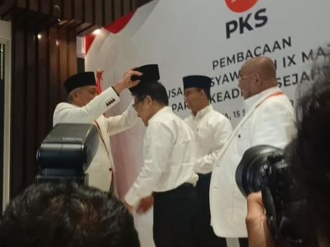 Presiden PKS Ahmad Syaikhu memakaikan peci hitam kepada Anies dan Cak Imin, usai me gumumkan dukungannya. (Foto/Istimewa)